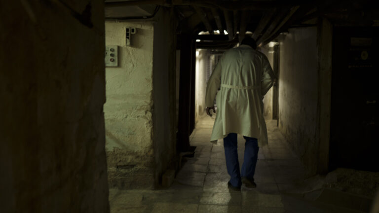 A health care worker walks in a hospital basement