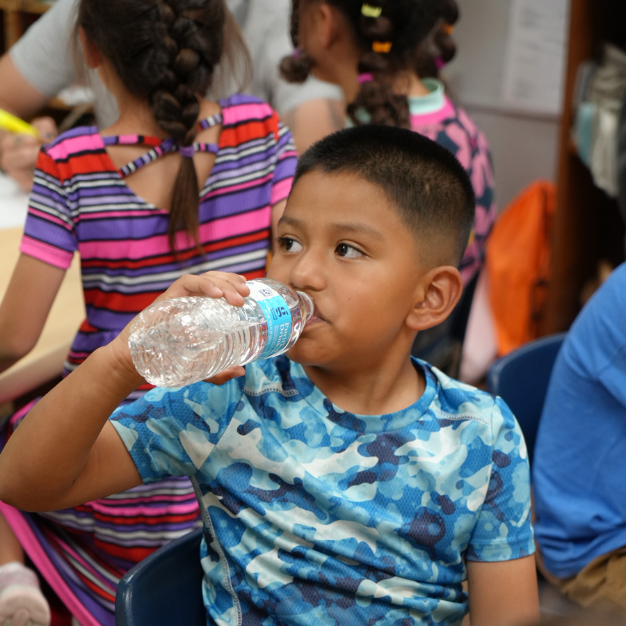 Child drinking from water bottle.