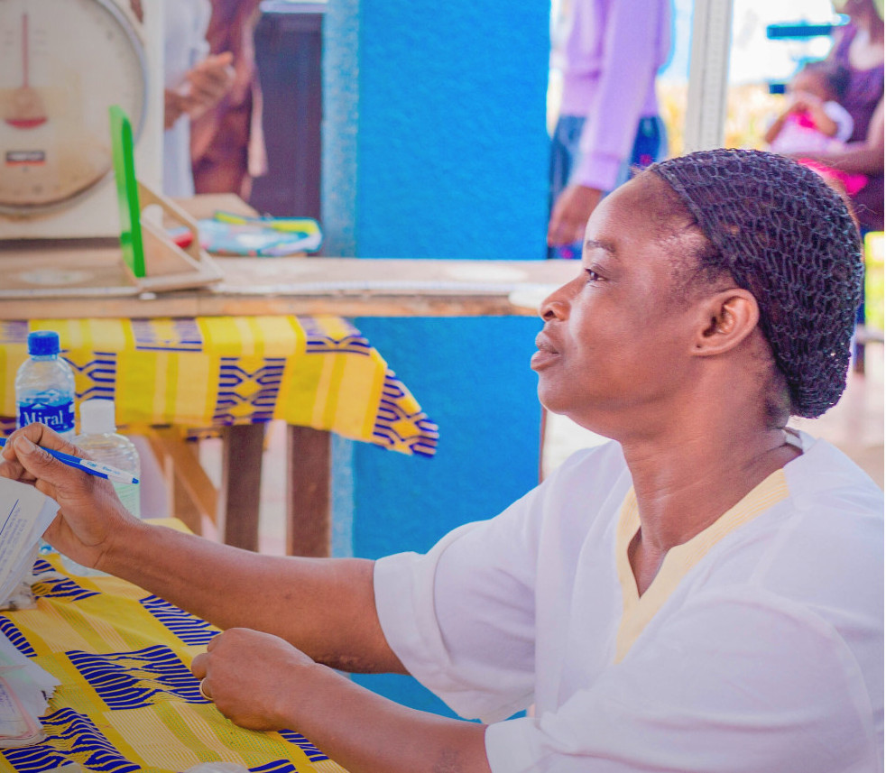 A female African health provider put a blood pressure cuff on a patient 