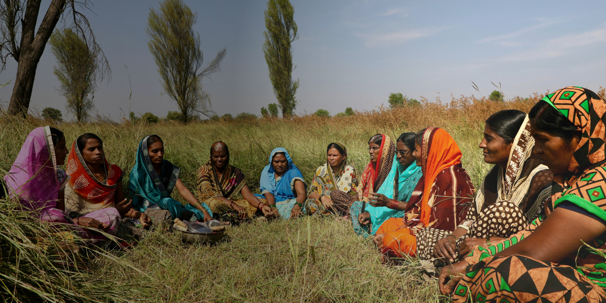 Female Indian health care providers sit in a row, listening