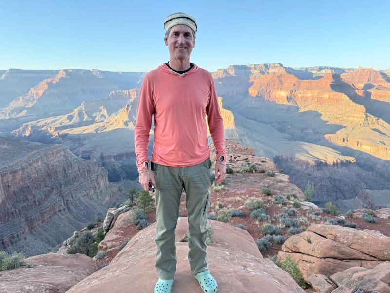 Dr. Bruce Struminger stands on a rock with a picturesque southwest canyon backdrop