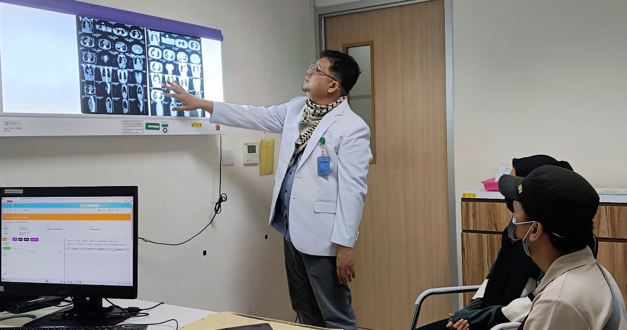 Dr. Rouly Pola Pasaribu reviews CT scans with patients at at Dr. Mohammad Hoesin Hospital in Palembang, Indonesia