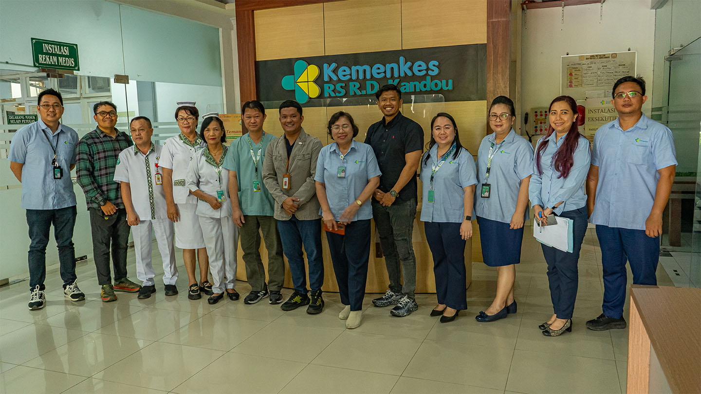 A group of healthcare providers in Indonesia posing for the camera in a hospital setting.