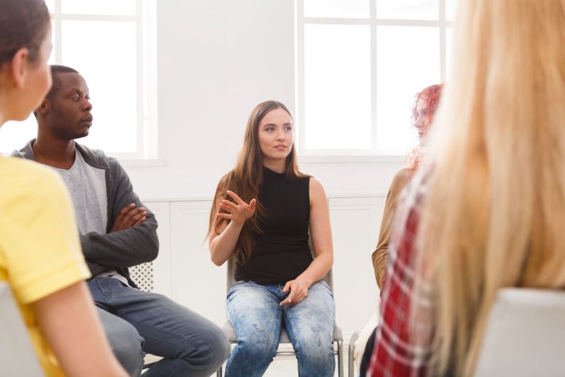 A group of middle-aged people sit in a circle.
