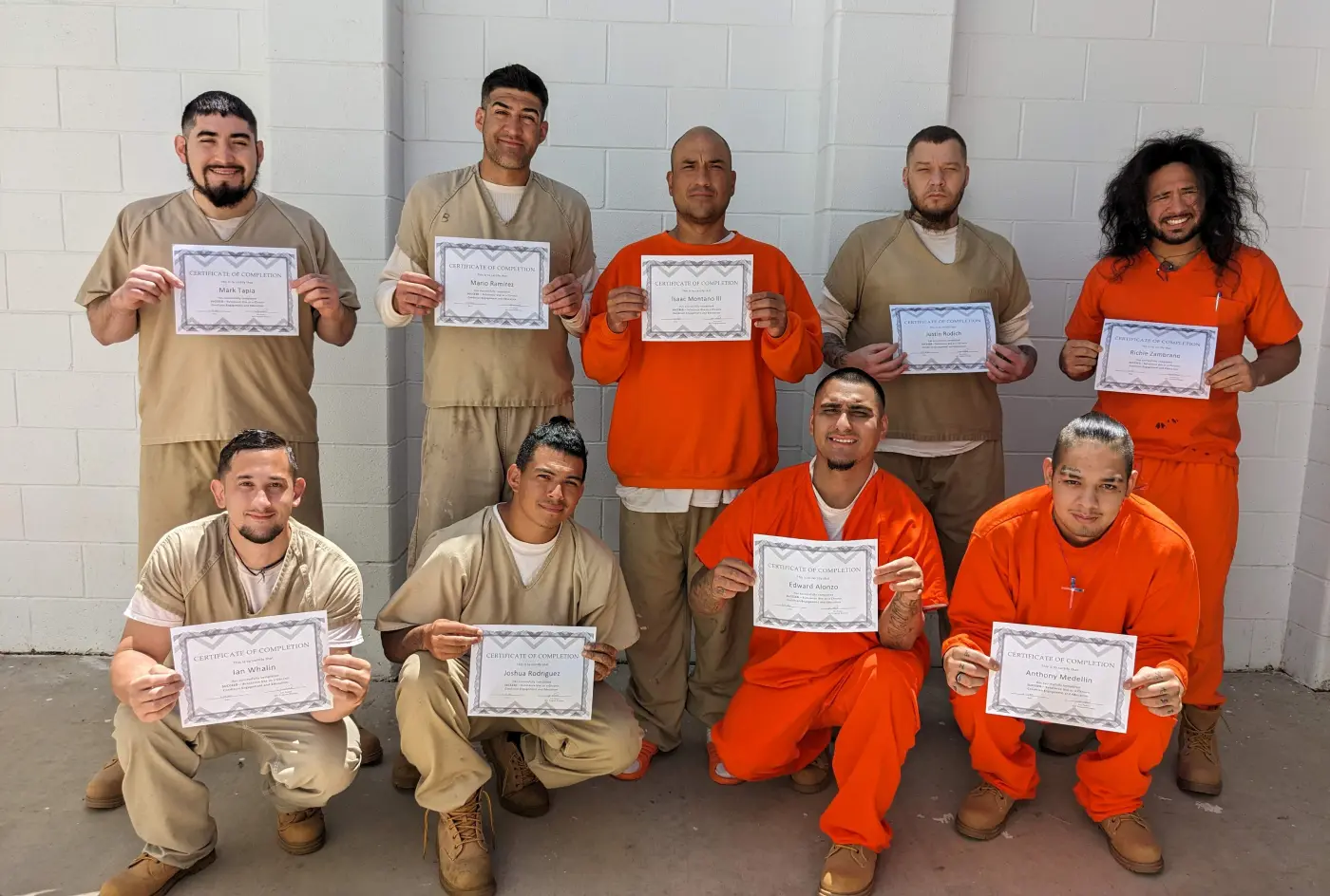 People in a detention center holding course completion certificates