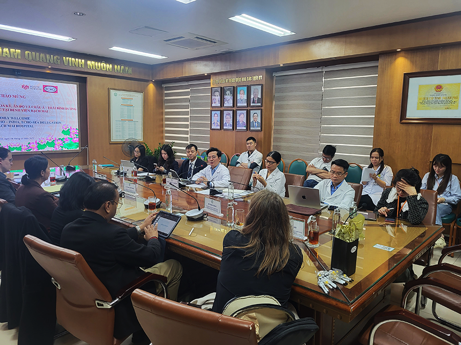 A conference room with men and women wearing lab coats and professional dress