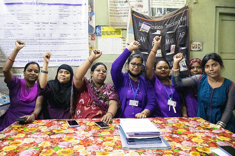 several women gather around a table putting a fist in the air in support for mental health