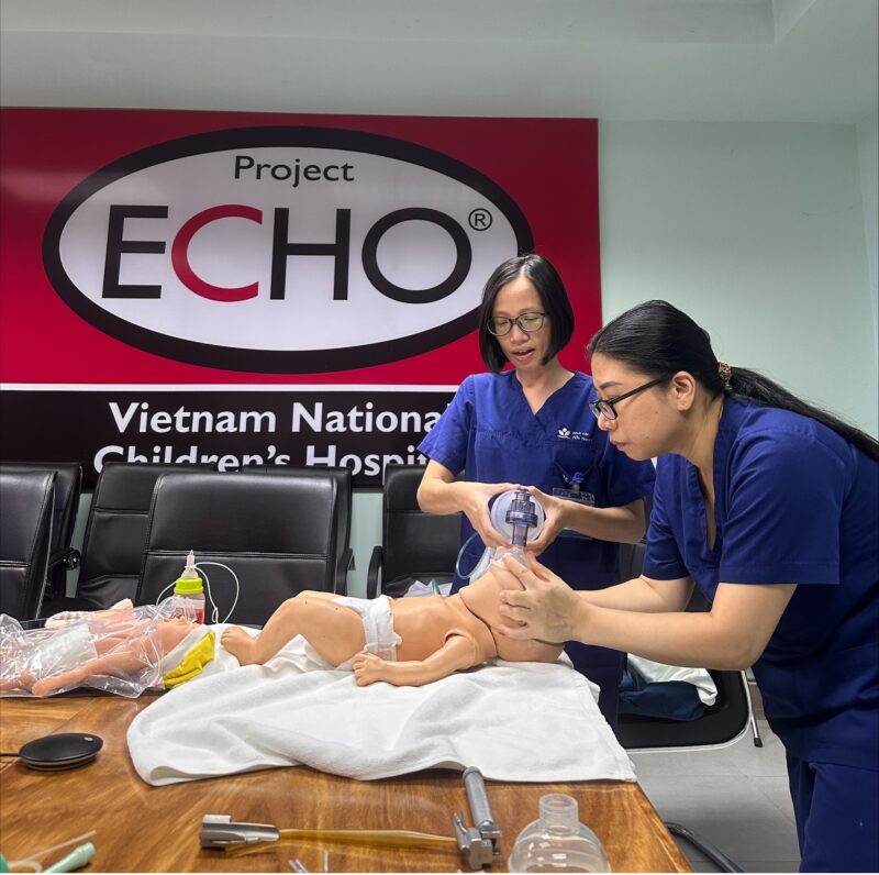 Two providers demonstrate opening airways on an infant manikin