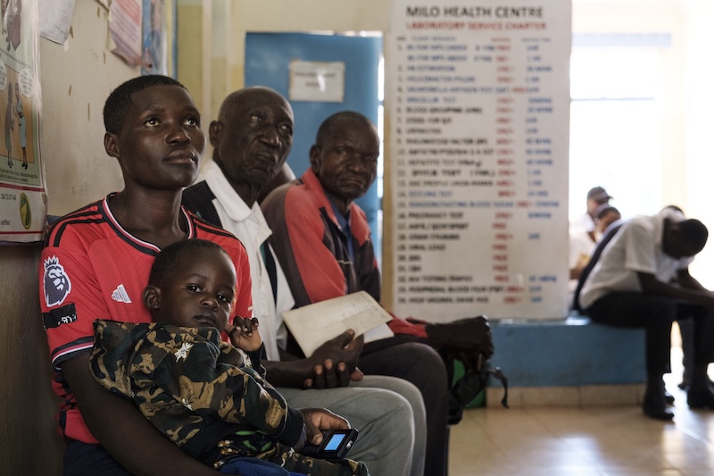 A young boy, and his father, sit in a hospital waiting room.