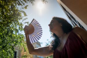 Woman with fan in direct sun
